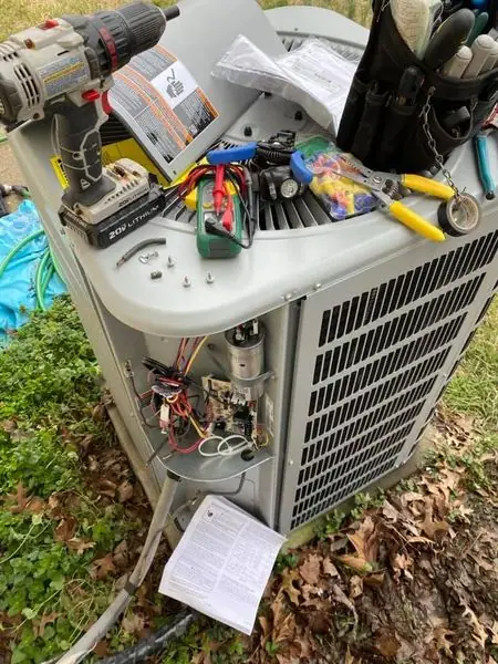 Outdoor condenser open mid-repair with tools on the unit
